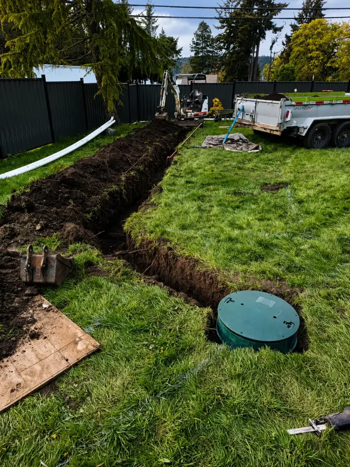 Green septic tank riser beside an open trench during the Nanaimo installation