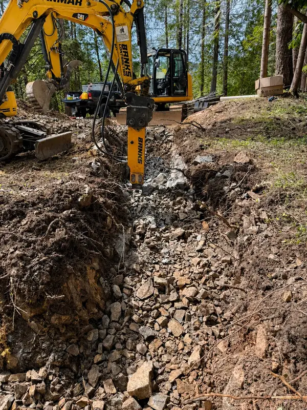 Hydraulic breaker excavating rock during a TTIS septic installation in Port Alberni