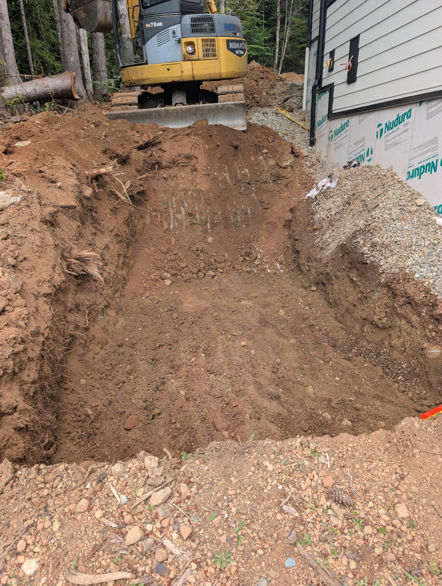 Excavation beside a house during the Sproat Lake septic installation